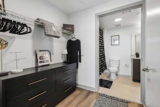 A black and white bathroom with a black cabinet and a white toilet.