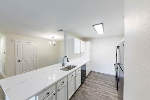 A kitchen with white countertops and a sink.