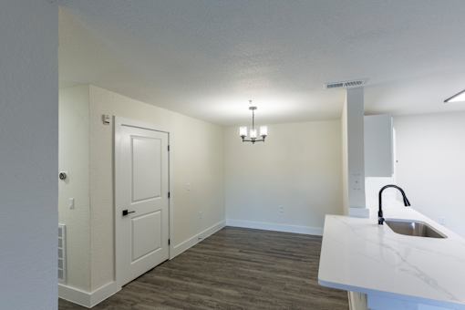 A white sink is on a counter in a room with a door and a chandelier.