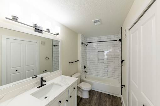 A white bathroom with a sink, toilet, and bathtub.