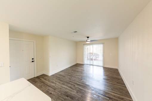 A spacious room with wooden flooring and a white sofa.