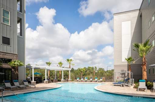 pool view with view of palm trees and clouds