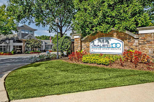 A sign for Premier Apartments is in front of a building.