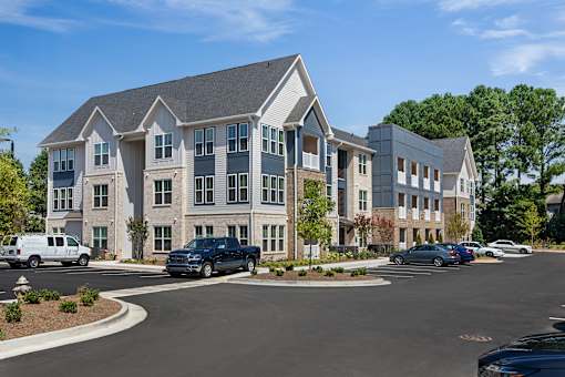 A large, modern building with a parking lot in front.
