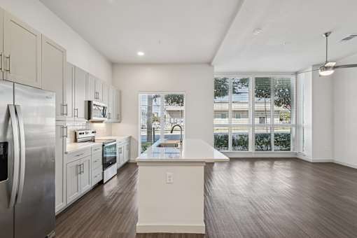 A kitchen with a refrigerator, microwave, and oven.