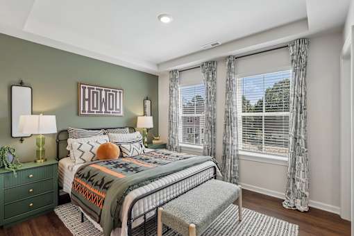A bedroom with a bed, nightstand, and window.