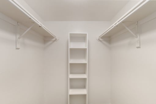 a walk in closet with empty shelves