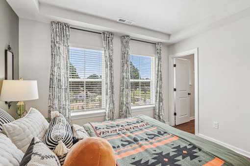 A bedroom with a large bed and a window with a view of the outside.