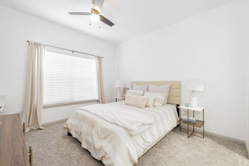 a bedroom with a bed and a ceiling fan