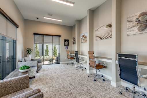 an office with a couch and chairs and a desk with a window