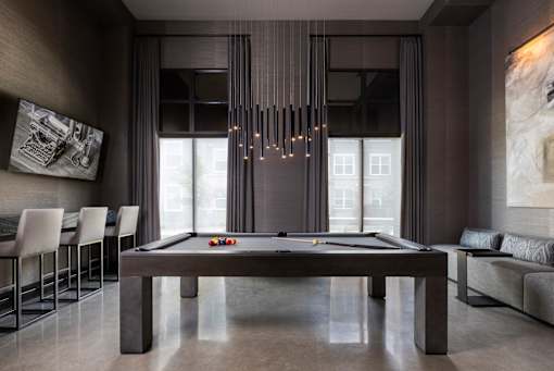 A pool table in a room with a light hanging from the ceiling.