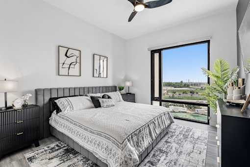 A bedroom with a large bed and a view of the outside.
