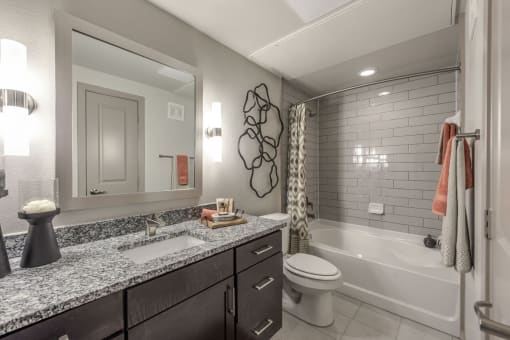 a bathroom with gray walls and a white bathtub