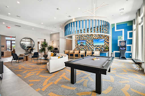 A billiard table is in the middle of a room with a patterned carpet.