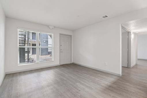 A room with a door and a window with blinds.