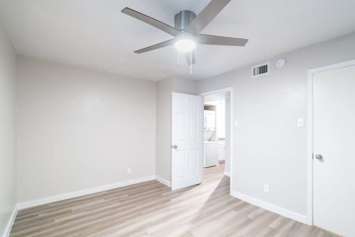 a bedroom with a ceiling fan and hardwood floors