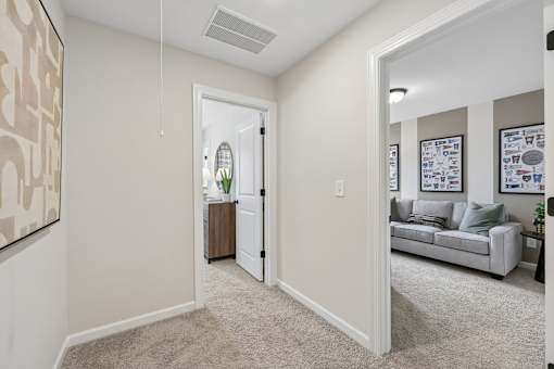 A living room with a grey couch and a white door.