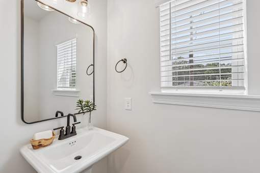 A bathroom with a white sink and a mirror.