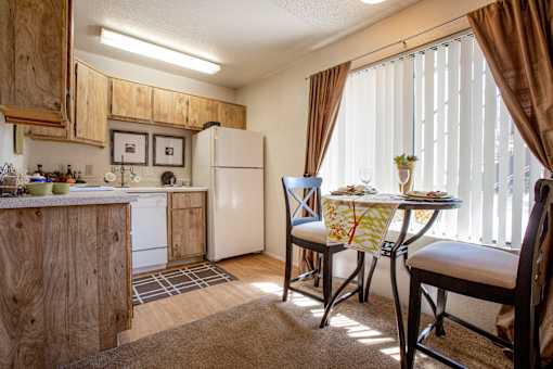 a kitchen and dining area with a table and chairs and a refrigerator