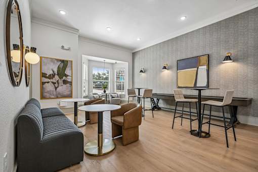 A modern living room with a grey sofa, a round table, and a painting on the wall.
