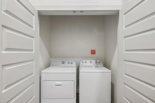 A white laundry room with a washer and dryer.