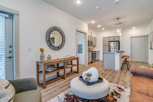 A modern living room with a round mirror and a white coffee table.