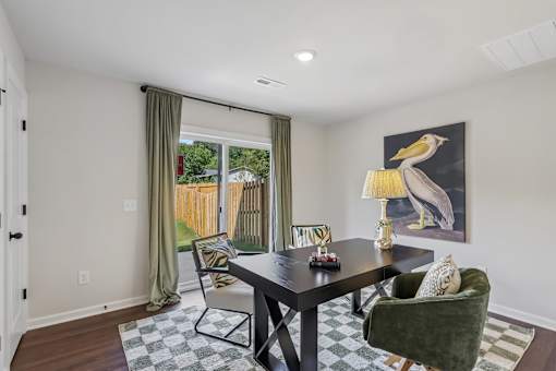 A dining room with a black table and green chairs.