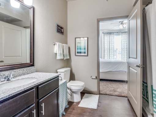 A bathroom with a toilet, sink, and mirror.