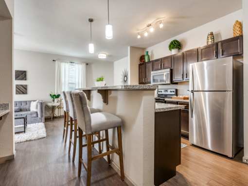 A kitchen with a bar stool in front of the counter.
