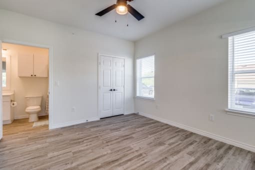 an empty living room with white walls and a ceiling fan