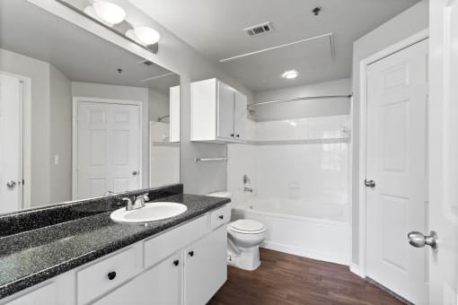 a bathroom with white cabinets and a sink and a toilet