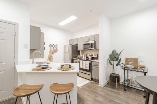 a kitchen with a breakfast bar and stools and a large kitchen with stainless steel