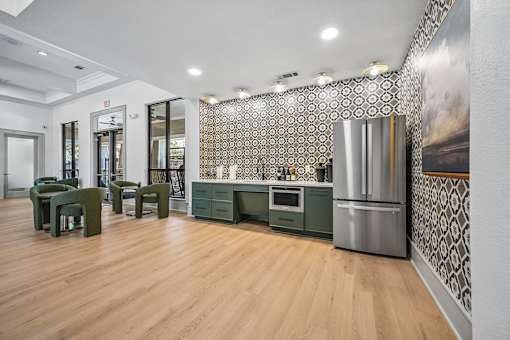 A kitchen with green chairs and a patterned wallpaper.