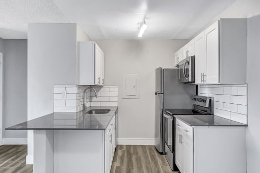a kitchen with white cabinets and stainless steel appliances