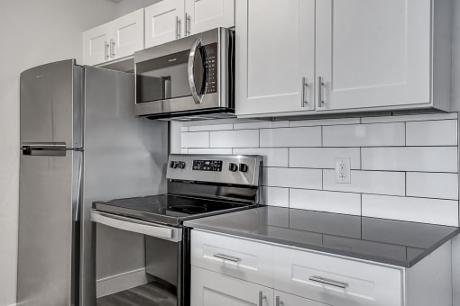 a kitchen with white cabinets and stainless steel appliances