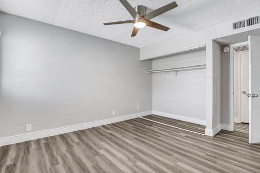 a bedroom with a ceiling fan and a closet