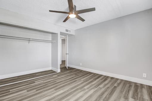 a bedroom with a ceiling fan and a closet with a sliding door