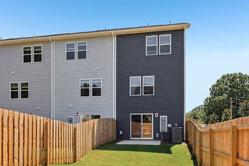 A grey two story house with a wooden fence in front.