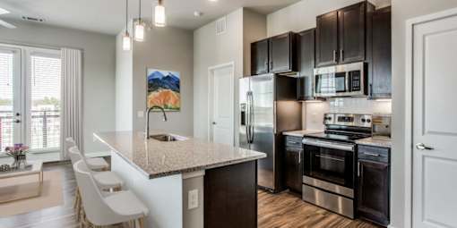 A kitchen with a granite countertop and stainless steel appliances.