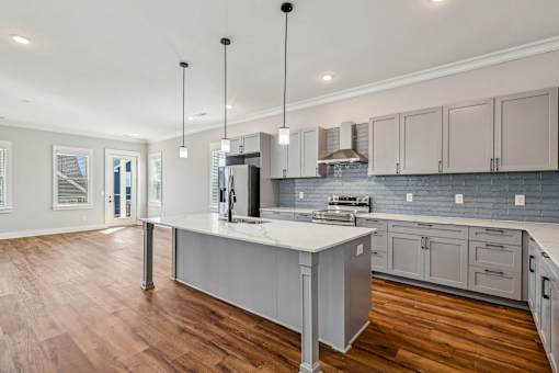 A modern kitchen with a large island and wooden floors.