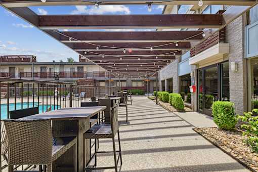 A patio with a table and chairs is covered by a roof.