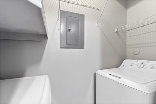 a white laundry room with a white washer and dryer and a white sink