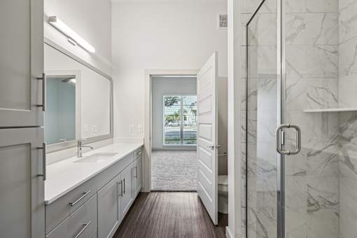 A bathroom with a marble wall and a window.