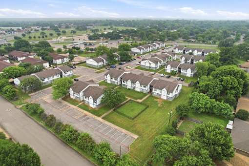A bird's eye view of a residential area with houses and a parking lot.