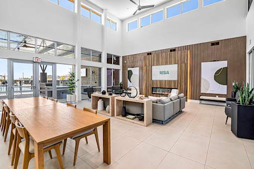 A modern office space with a long wooden table and chairs, a couch, and a reception desk with a sign that reads "RESIA".