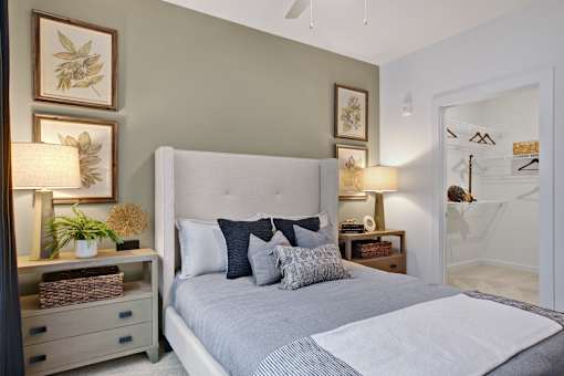 A bedroom with a large bed and a nightstand with a lamp.