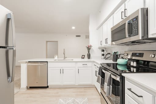 a renovated kitchen with white cabinets and stainless steel appliances