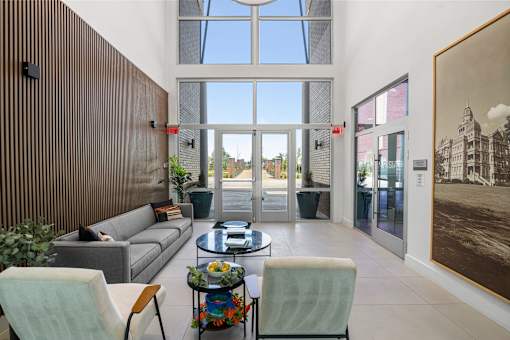 A living room with a grey couch, a coffee table, and a large painting on the wall.