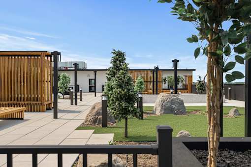 A modern building with a wooden fence and a tree in front.
