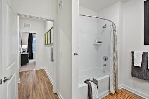 A white bathroom with a walk in shower and a towel hanging on the side.